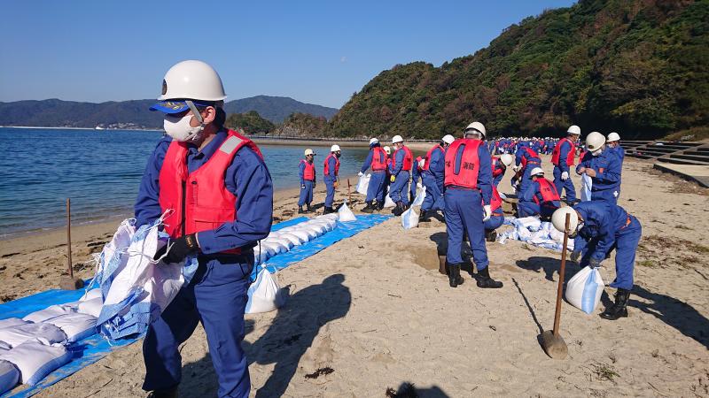 砂浜に並べられる、1個20キロの砂袋たち